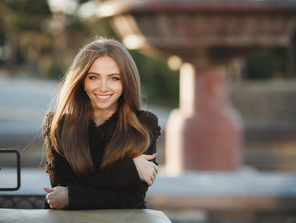 زن جوان با پوست سالم و شاداب در فضای باز و نور طبیعی