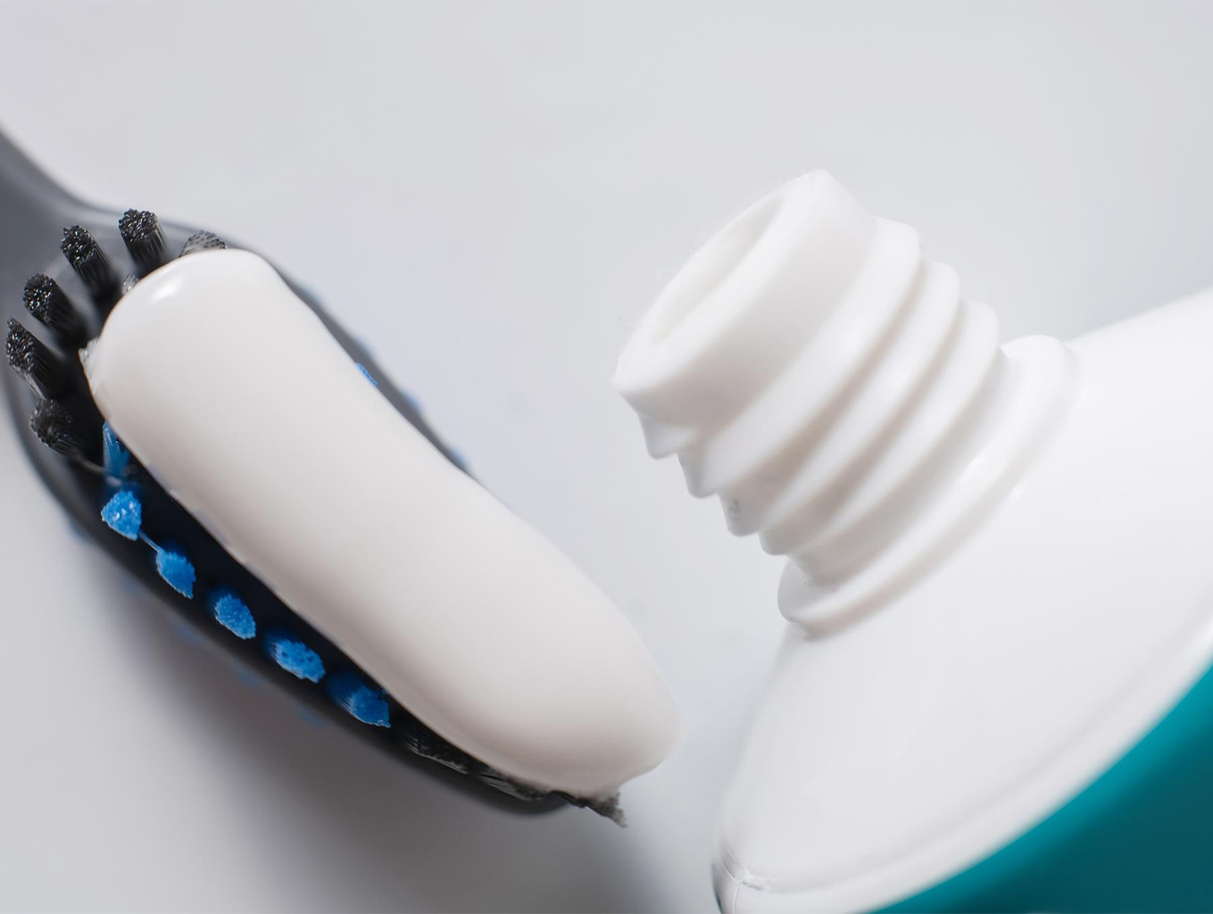 این عکس نمای نزدیک از خروج خمیردندان روی مسواک را نشان میدهد. تصویر برای صفحات مرتبط با معرفی خمیردندان، تکنیک صحیح استفاده، یا مقایسه بافت و کیفیت محصول کاربرد دارد.